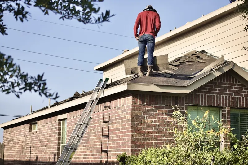 Professional roofer working on a residential roof in Wynnewood